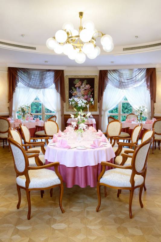 Pałac w Czarnym Lesie nr 2 (Sala restauracji, w środku owalny stół otoczony krzesłami, w tle obraz, stół nakryty do kolacji z różowym obrusem, w tle dwa stoły)