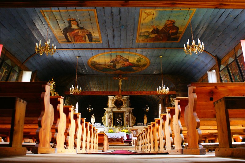 Parafia pw. Świętej Trójcy w Koszęcinie nr 2 (Wnętrze kościoła, z prawej i lewej ławki w tle ołtarz, na górze malowidła na suficie)