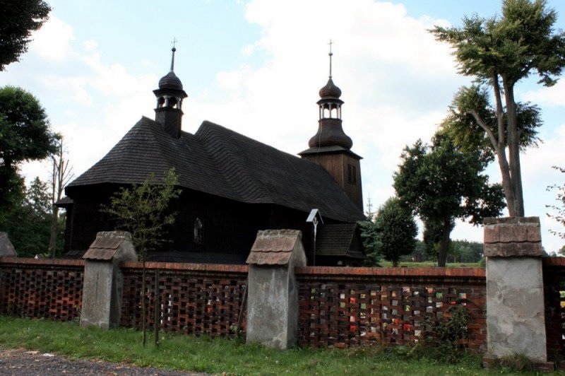 Parafia pw. Świętej Trójcy w Koszęcinie nr 8 (Widok kościoła z za płotu w tle cmentarz)