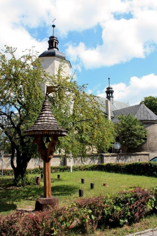 Parafia św. Katarzyny w Woźnikach nr 2 (Dzwon obok kościoła, w tle kościół)