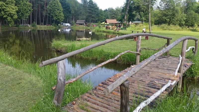 Łowisko Leśnica nr 2 (Drewniany mostek ustawiony na zbiorniku wodnym. W tle dalsza część zbiornika i niewielkie budynki.)