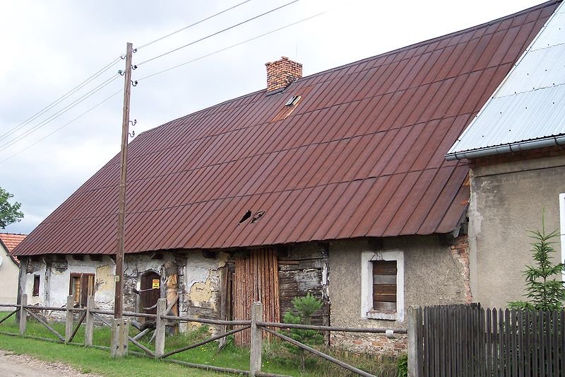 Fajczarnia w Zborowskiem nr 1 (Widok manufaktury fajek od ulicy fabrycznej, starty budynek z metalowym spadzistym dachem (czerwonym))