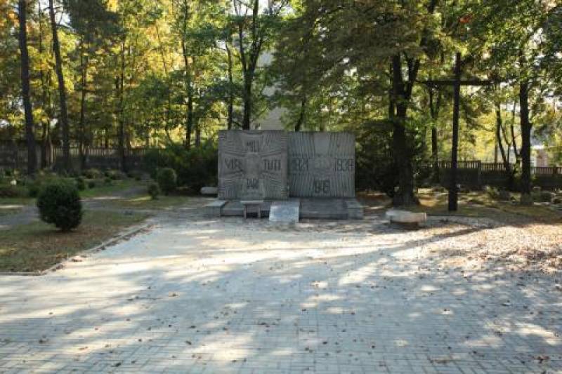 Pomnik Żołnierzy Wojska Polskiego nr 1 (Teren Cmentarza Wojskowego. Szary pomnik, do którego prowadzi chodnik. W tle drzewa.)