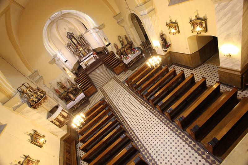 Kościół p.w. Św. Mikołaja nr 1 (Widok z góry na wnętrze Kościoła p.w. Św. Mikołaja w Lublińcu. Brązowe ławki ustawione w rzędach. Z przodu widoczny główny ołtarz oraz ołtarze boczne.)