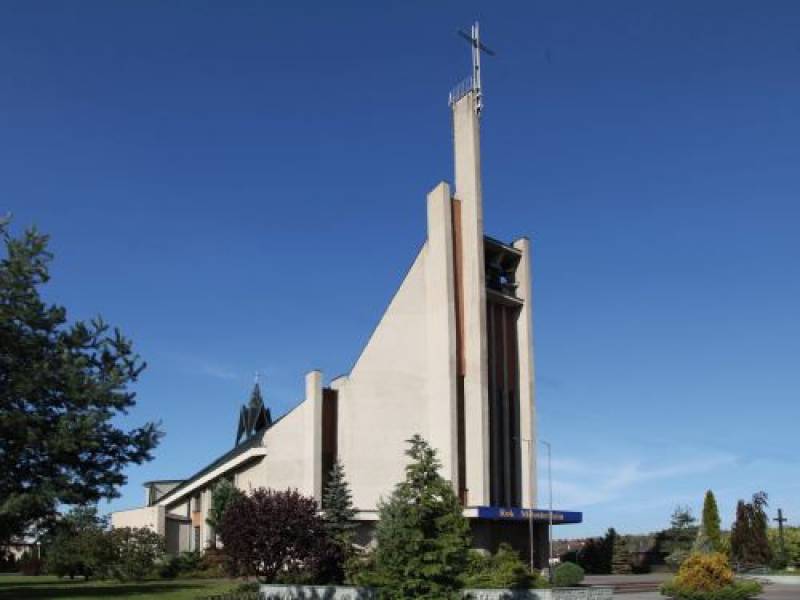 Kościół pw. NMP Matki Kościoła (widok fasady kościoła, w tle drzewa i przykościelny krzyż)